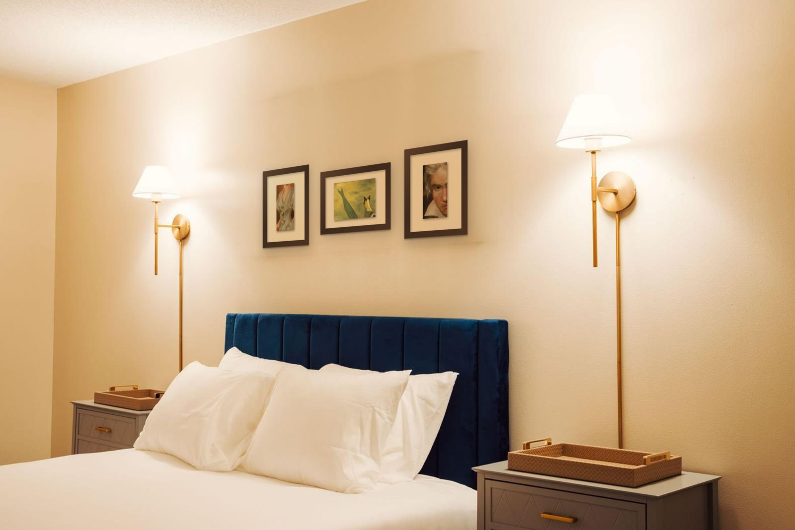 The Dog and his Shadow, original painting by Riya Kumari, framed above a hotel bed, with two other pieces